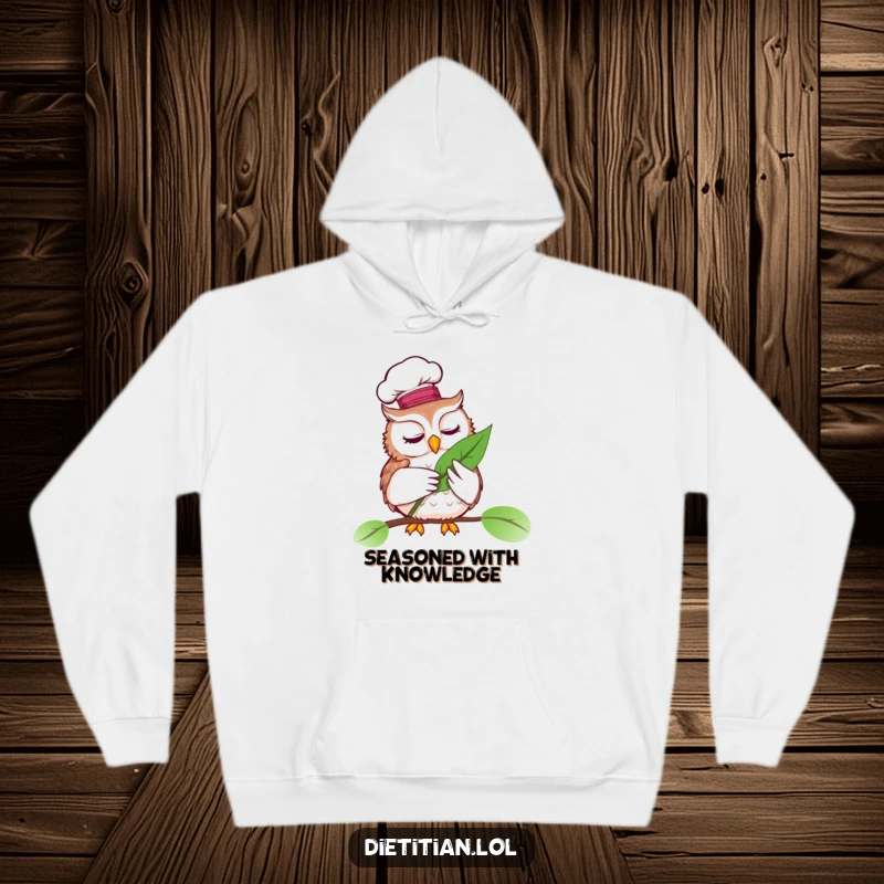 Funny hoodie with a wise owl wearing a chef hat, examining a vibrant leaf, ideal funny gift.